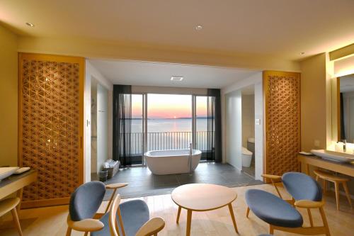 a bathroom with a tub and a table and chairs at Beach Hotel Sunshine in Ishigaki Island