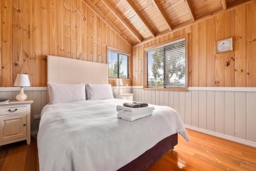 1 dormitorio con 1 cama grande en una habitación con paredes de madera en Hazelcreek Cottages, en Exeter