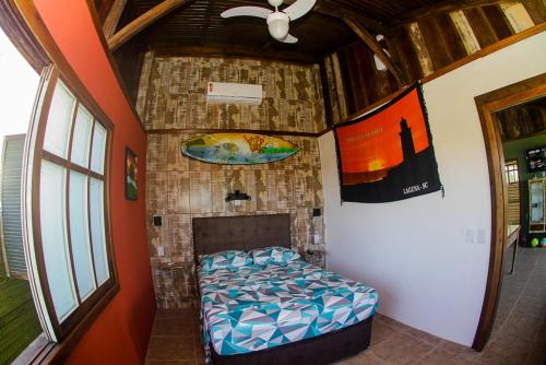 Habitación con cama y pared de ladrillo en Cigana's House 1 - Região do Farol de Santa Marta, en Laguna