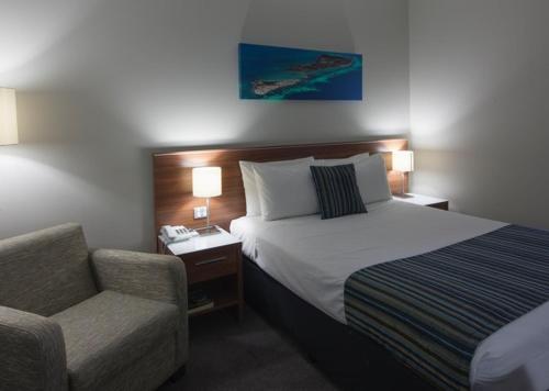 a hotel room with a bed and a chair at Ocean Centre Hotel in Geraldton