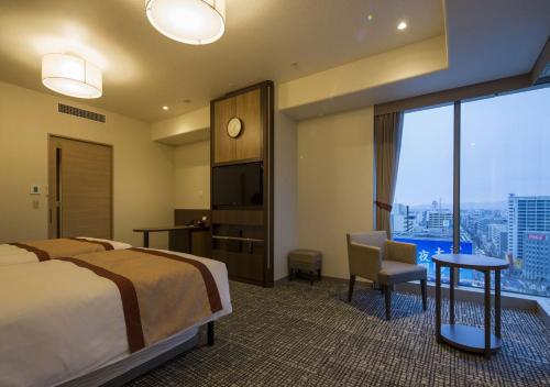 a hotel room with a bed and a large window at Hotel Monterey Fukuoka in Fukuoka