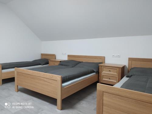 une chambre avec trois lits et une table de nuit dans l'établissement Vila pod Majákem, à Přítluky
