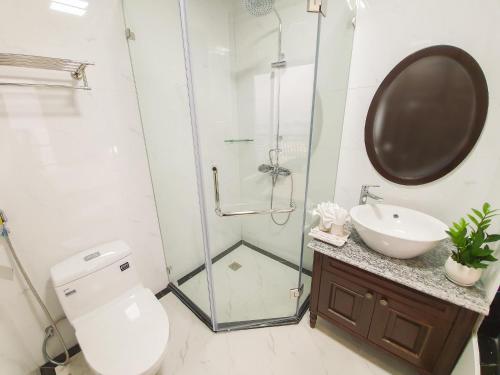 uma casa de banho com um chuveiro, um WC e um lavatório. em La Stella Hotel em Ha Long