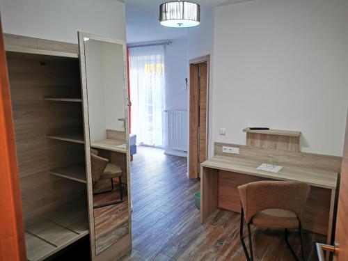 a room with a desk and a table and chairs at Pension unterm Schlossturm in Haag in Oberbayern