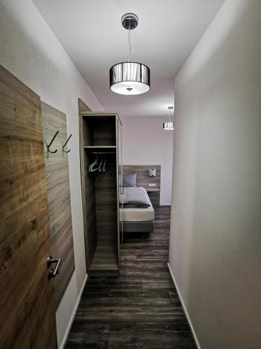 a hallway with a room with a bed and a mirror at Pension unterm Schlossturm in Haag in Oberbayern