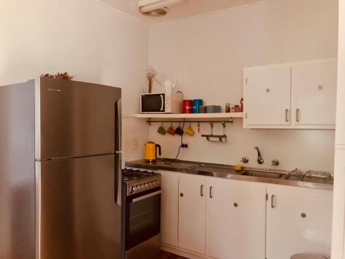 a kitchen with a refrigerator, stove, sink and cabinets at Ella May Holiday Flats in Tuross Heads