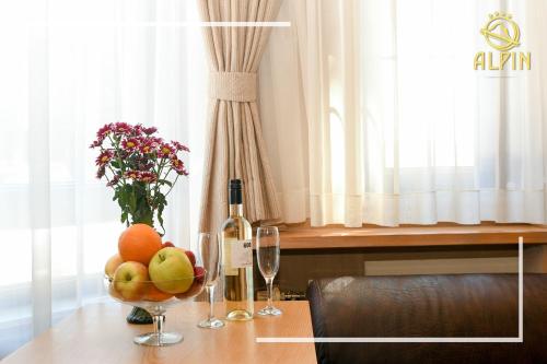 a table with a bowl of fruit and a bottle of wine at Alpin Borovets, Алпин Боровец in Borovets