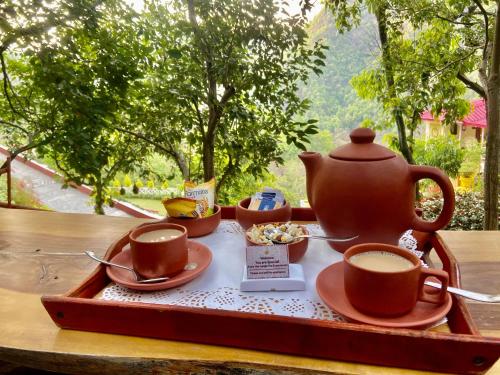 a tray with a tea pot and cups on a table at Veda5 Ayurveda & Yoga Retreat in Rishīkesh