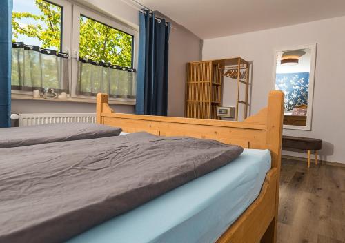 a bedroom with a bed and a mirror and windows at Fewo Tante Else in Bodenwerder