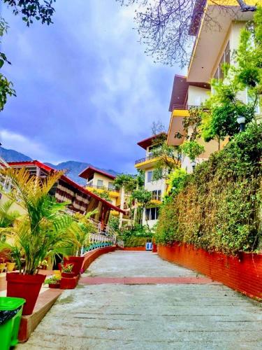 a walkway in front of a building with plants at Veda5 Ayurveda & Yoga Retreat in Rishīkesh