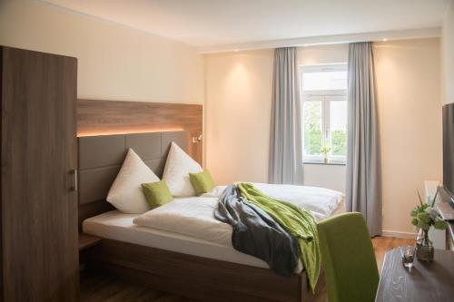 1 dormitorio con cama y ventana en Landgasthof-Hotel Zur Linde, en Großenlüder