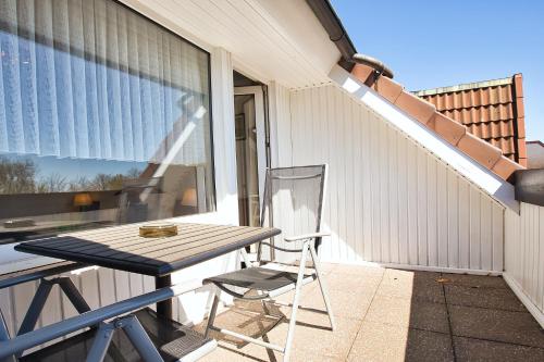 a picnic table and a chair on a patio at Hotel Meeresruh Garni in Cuxhaven