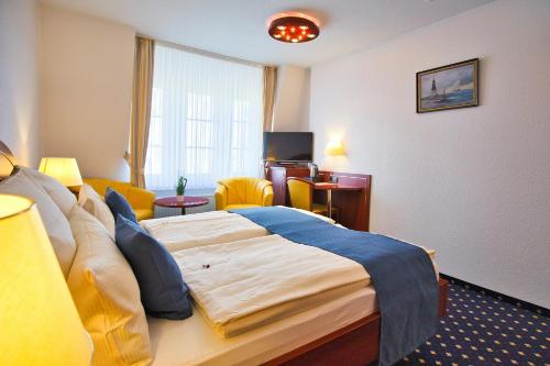 a hotel room with a bed and a living room at Hotel Meeresruh Garni in Cuxhaven