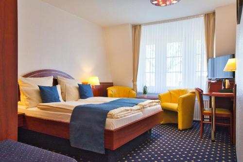 a hotel room with a bed and a chair at Hotel Meeresruh Garni in Cuxhaven