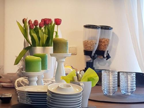 een tafel met borden en een vaas met rode tulpen bij Pension Seeschlösschen in Mölln