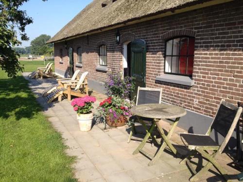 a patio with a table and chairs and a building at De Aze in Terwolde