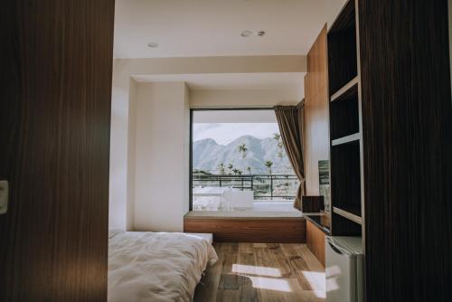 1 dormitorio con cama y ventana grande en Ruili Tea Villa en Meishan