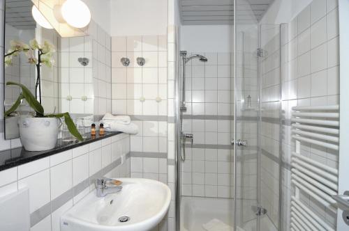 ドルトムントにあるHotel NeuHausの白いバスルーム(シャワー、シンク付)
