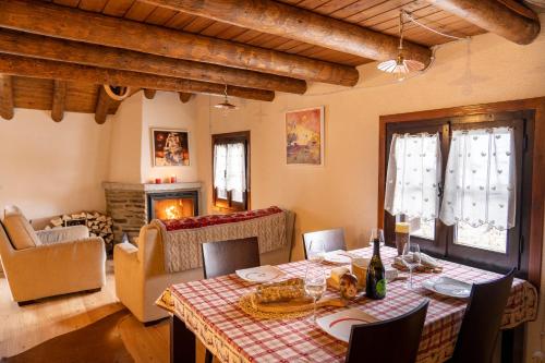 una sala da pranzo con tavolo e un soggiorno di Baita Mirellina - Case di Viso a Ponte di Legno