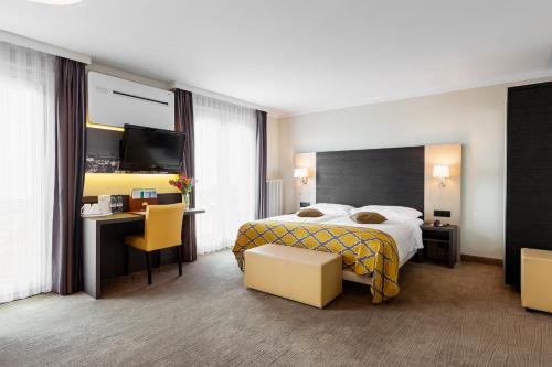 a hotel room with a bed and a table and chairs at Hôtel Bellerive in Lausanne