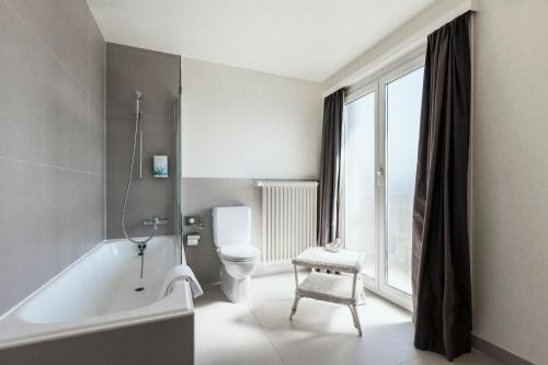 ローザンヌにあるホテル ベッレリーヴェのバスルーム(バスタブ、トイレ付)、窓が備わります。