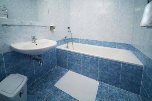 a white toilet sitting next to a bath tub in a bathroom at Hotel Krystal in Prague