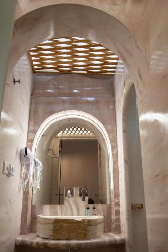 a bathroom with a large mirror and a bath tub at Alta Vista Naxos in Naxos Chora