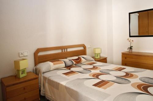 a bedroom with two beds and a mirror at AT031 Comunidad con 2 piscinas, a 5 min a pie de la playa in Torredembarra