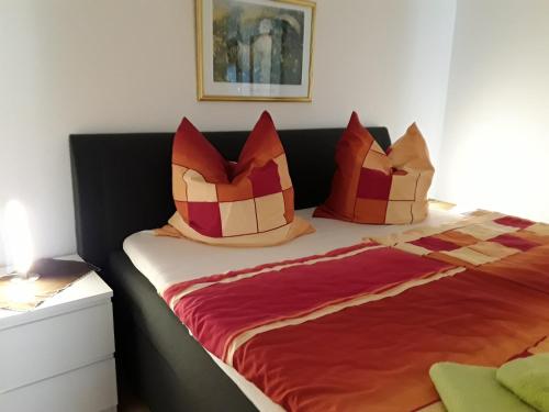 a bedroom with a bed with red and orange pillows at Tanne Altenau in Altenau
