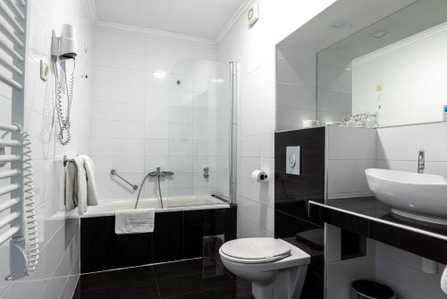 a white bathroom with a sink and a toilet at Hotel Sveti Kriz in Trogir