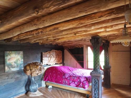 a bed in a room with a wooden ceiling at Village.insolite in Montagny-sur-Grosne