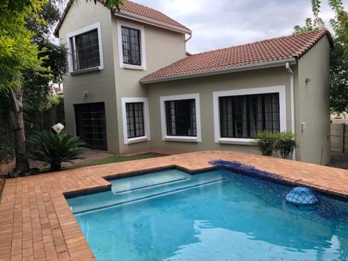a large swimming pool in front of a house at Phil's Country Loft- Power backup in Johannesburg