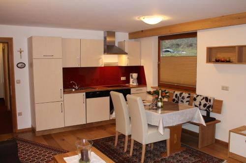 una cucina con tavolo e sedie e una cucina con lavandino di Appartements Zerzer a Ried im Oberinntal