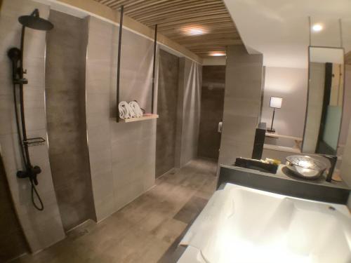 a bathroom with a shower and a bath tub at OUGE Motel Kaohsiung in Kaohsiung