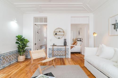 a living room with a white couch and a table at Casa Boma Lisboa - Typical and Spacious Apartment - Lapa II in Lisbon