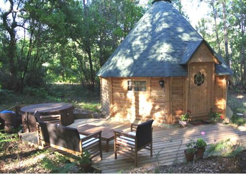 a log cabin with a table and chairs on a deck at Lo Rey du Lac in Soorts-Hossegor