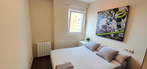 a bedroom with a bed and a picture on the wall at Acogedor apartamento en Ronda Outeiro 210 in A Coruña