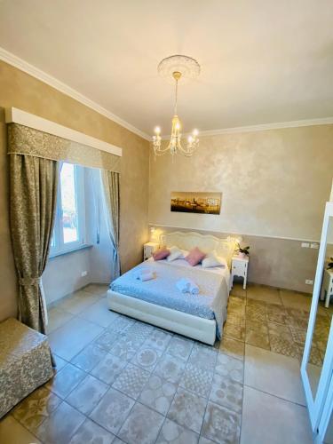 a bedroom with a bed and a chandelier at Domus Valadier B&B Guesthouse in Fiumicino