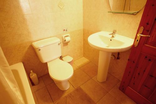 a bathroom with a toilet and a sink at Hilltop Chalet in Pissouri