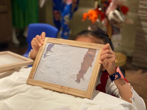a young child holding up a picture of a map at Banyan Tree Yangshuo in Yangshuo