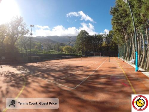 a tennis court with trees and mountains in the background at Casa Magnolia in Castelbuono