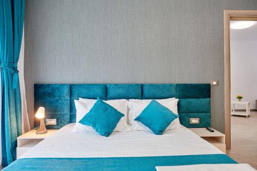 a blue and white bed with blue and white pillows at Sea Love apt SPA n Pools Beach Resort in Mamaia Nord