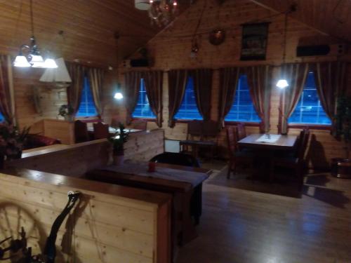 Dalselv hotell في Stien: غرفة كبيرة بها نوافذ زرقاء وطاولات وكراسي
