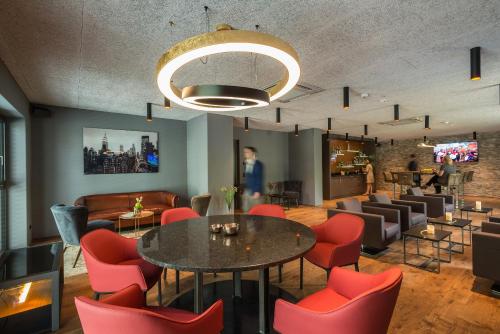 um restaurante com uma mesa e cadeiras vermelhas em Golden Ball, Exclusive Serviced Apartments Munich em Aschheim