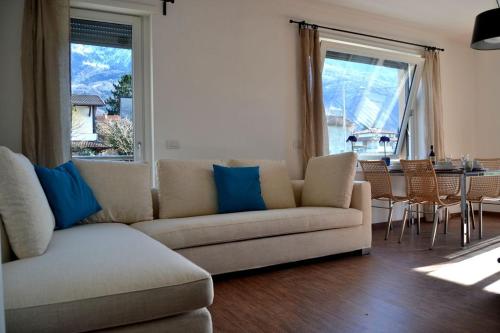 een woonkamer met een bank en een tafel met stoelen bij Casa Conte in Colico