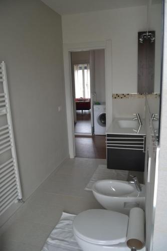 a white bathroom with a toilet and a sink at Casa CONTE air conditioning, near Station, Center and Ferry to Bellaggio in Colico