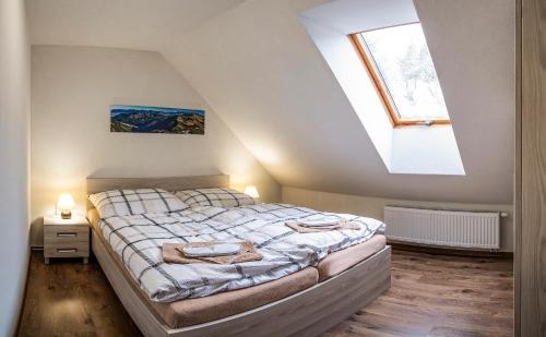 ein Schlafzimmer mit einem großen Bett im Dachgeschoss in der Unterkunft Apartmány Pemmeva in Vyšná Boca
