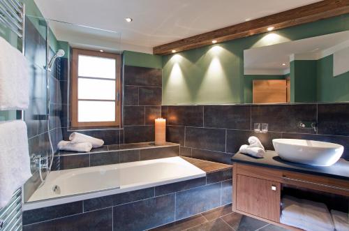 y baño con bañera y lavamanos. en Serfaus Mountain Lodge, en Serfaus