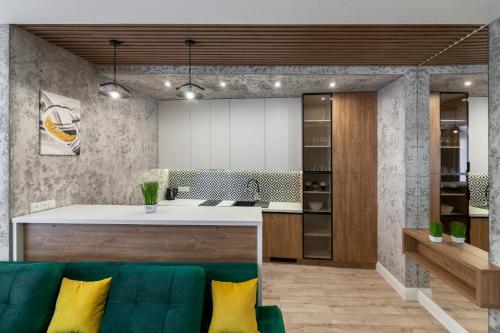 Il comprend un salon avec un canapé vert et une cuisine. dans l'établissement Royal VIP Apartment on Pidmurna 24, à Lviv