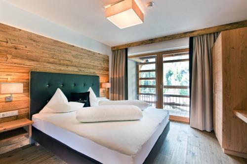 a bedroom with two beds and a large window at Serfaus Mountain Lodge in Serfaus